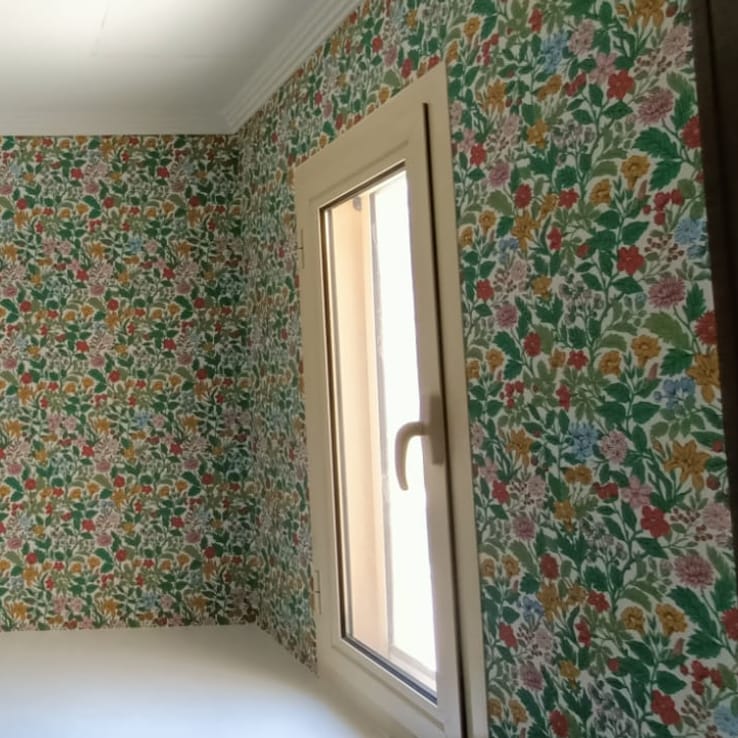 Floral print wallpaper installed around a bedroom window