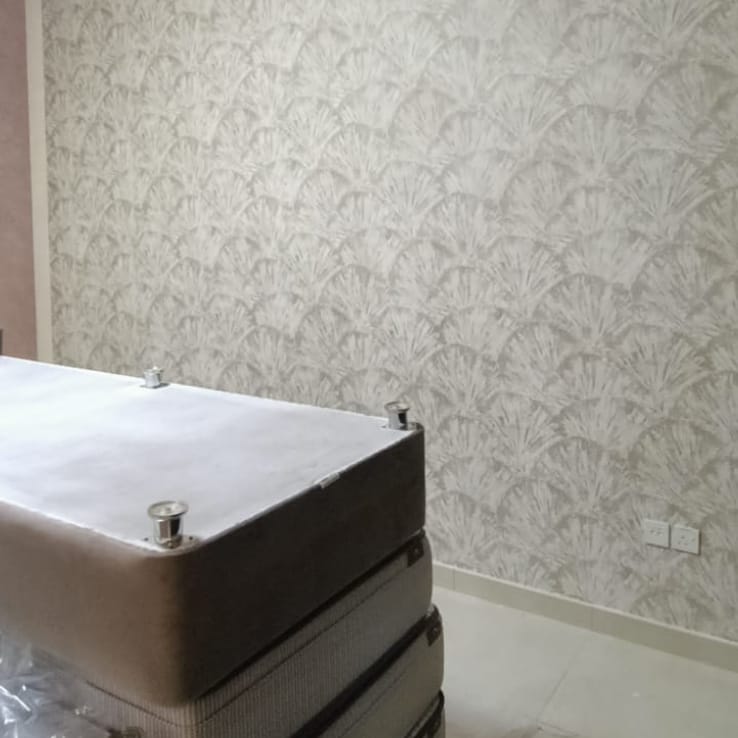 Textured floral wallpaper installation in a bedroom